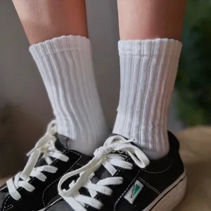 Primer plano detallado de calcetines blancos de algodón acanalado con zapatillas casuales.
