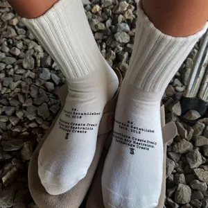 Detailed view of white cotton mid-calf socks featuring unique English text print, casual style.