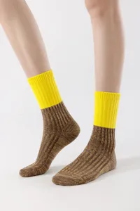 Detailed view of colorblocked mid-calf socks with yellow ribbed top and brown knit texture.