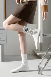 Detailed view of women's thick knit distressed embroidered cotton mid-tube socks white.