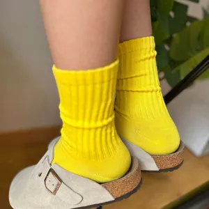 Vista detallada de calcetines acanalados amarillo brillante con zuecos, estilo cómodo y casual.