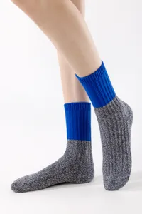 Knit crew socks detail showing blue ribbed cuff and heather gray snowflake texture design.