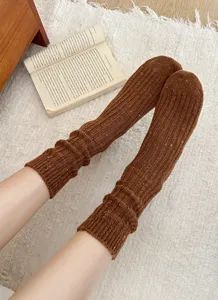 Cozy brown knit leg warmers detail shot showing soft textured wool fabric texture and comfortable fit.