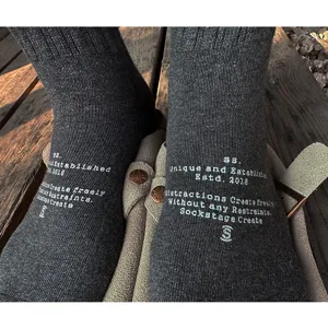 Detail view of dark grey cotton crew socks featuring custom text prints and comfortable fit.