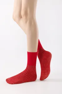 Close-up detail of red knit ribbed mid-tube socks, showing fine textured fabric texture.
