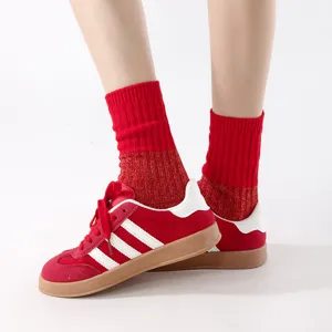 Detailed close-up of red ribbed knit mid-tube socks worn with casual sneakers, stylish soft sock.