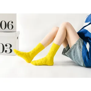 Detailansicht gelber Plüsch-Socken mit Blumenmuster, weiche warme dicke Wintersocken.