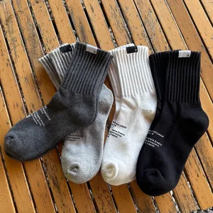 Detail view of Japanese style men casual cotton mid-tube socks with side print and cuff label.