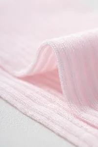 Close-up detail view of light pink breathable ribbed knit fabric showing fine mesh.