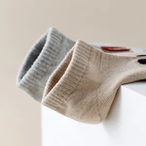 Detailed close-up shot of minimalist ribbed cotton ankle socks in neutral grey and khaki tones.