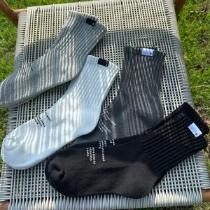 Men's casual solid color mid-calf cotton socks with print and tag detail, breathable and stylish.