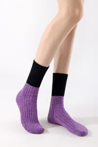 Detailed view of women knit mid-calf socks with black ribbed cuff and purple heather texture.