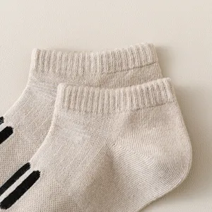 Casual beige ankle socks with knit stripe details, comfortable ribbed cuff design for daily wear.