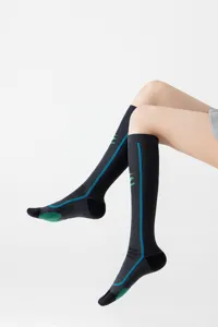 Detail view of black compression athletic socks with breathable mesh, blue and green stripe accents.