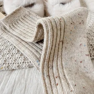 Cozy women's thick knit wool socks in soft beige with colorful flecks for winter warmth.