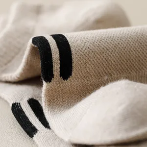 Detailed close-up view of beige knit ankle socks featuring a modern black stripe pattern.