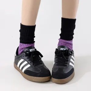 Close-up detail shot of chunky knit slouchy mid-calf socks with color-blocked design.