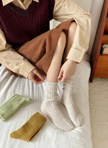 Close-up view of cozy wool speckled mid-calf socks in daily autumn room scene detail.