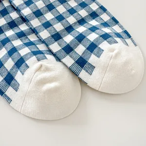 Blue white plaid cotton socks detail close-up, soft knit fabric with solid white toe cap.