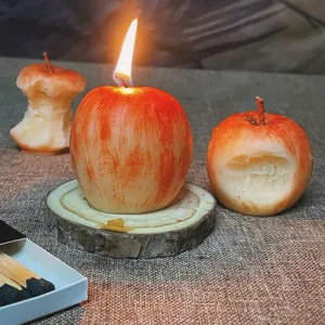 Detail shot of handcrafted apple scented candles with bite and core design, cozy home decor.