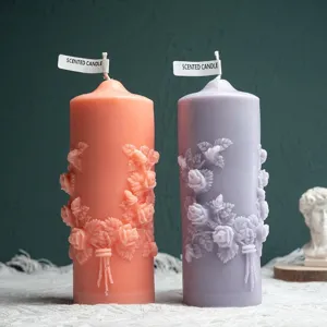 Embossed rose pillar scented candle set with floral wreath design for home decor display.
