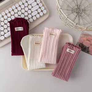Detailed shot of cute women's autumn winter ruffle ribbed cotton stack socks with small labels.