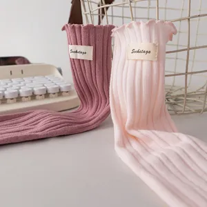 Women sweet ruffle ribbed mid tube socks detail shot showing fabric texture and cute label design.