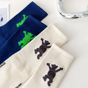 Detailed view of trendy Korean style couple long socks featuring cute dancing bear knit patterns.