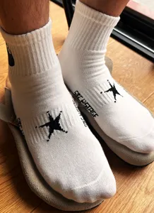 Calzini bianchi a metà polpaccio con ricamo stella nera e design streetwear alla moda.