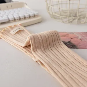 Cozy beige ribbed cotton socks with cute lettuce edge and woven label detail for women autumn style.