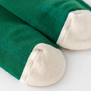 Vista de detalle cercana de calcetines de compresión deportivos verdes con punta blanca.