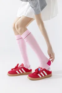 Vista detallada de calcetines deportivos de compresión de malla rosa, diseño fitness de rodilla.