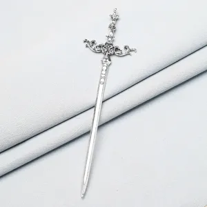 Close-up detail of vintage metal sword hair stick, intricate dagger hilt design for buns.