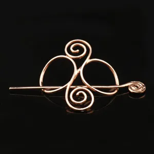 Closeup view of the vintage rose gold metal Viking Celtic hair pin, showing intricate spiral design.