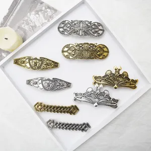 Close-up of intricate vintage metal Viking Celtic hair clips with detailed retro carved patterns.