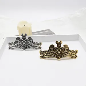 Vintage metal hair clip with intricate wing design in silver and bronze retro finishes.