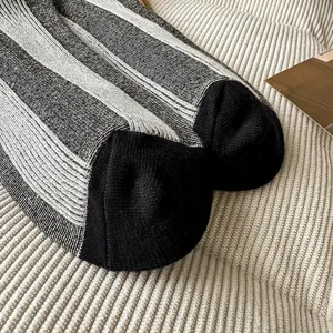 Close-up detail of stylish vertical striped mid-calf socks featuring contrasting knit texture.