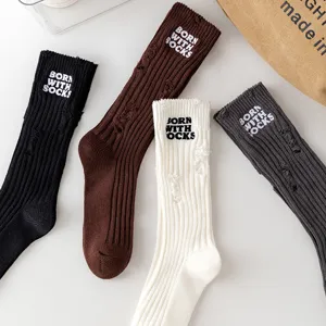 Distressed ribbed knit socks with embroidery detail, mid-calf length, cozy cotton blend.