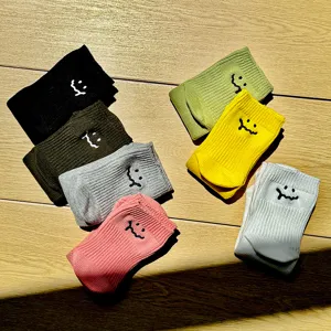 Close-up detail of colorful thick needle casual socks featuring embroidered smile designs.