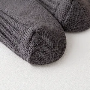 Detailed view of dark gray knit socks showing fine texture, premium cotton material, winter warm.