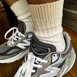 Detailed shot of solid color ribbed crew socks worn with sneakers, thick knit cotton style.