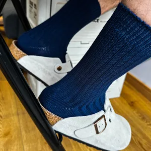 Close-up detail of solid color ribbed mid-calf knit socks in deep blue, casual daily wear.