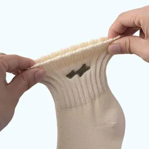 Unisex beigefarbene Kurzsocken mit elastischem geripptem Bündchen und gesticktem Bärchen-Motiv.