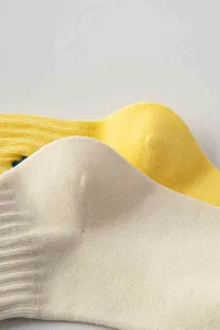 Nahaufnahme von trendigen kurzen Socken mit gerippten Bündchen und feiner Stickerei, weich.