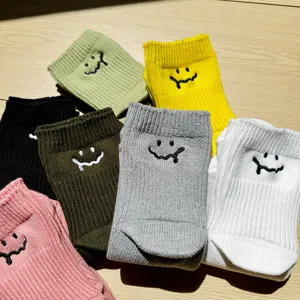 Close-up detail of casual cotton socks with embroidered melting smiley face, thick knit.