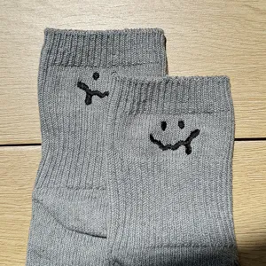 Grey cotton short socks detail view, thick knit design with cute smiley embroidery, casual style.