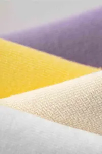 Stoffmaterial Detail Nahaufnahme mit weicher Baumwolltextur und mehrfarbigen Stoffschichten.