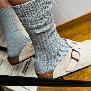 Detail shot of grey ribbed crew socks worn with suede clogs, showing soft texture and cozy fit.