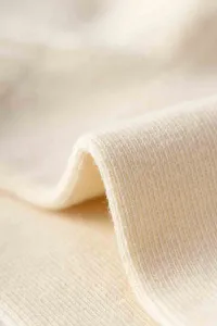 Nahaufnahme von weichem Strickstoff mit feiner Textur, sauber und in hoher Qualität.
