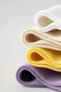 Bequeme weiche Baumwollsocken in vier schönen Farben weiss, beige, gelb und lila gestapelt.